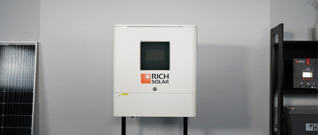 Hybrid Inverter beside white solar panel mounted on black cabinet.